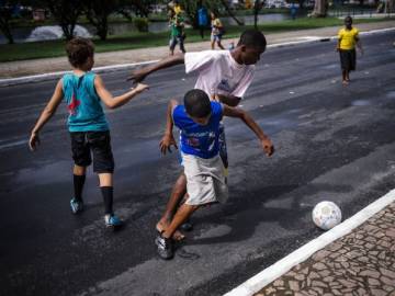 Niños jugando al fútbol en la calle
