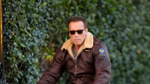 Arnold Schwarzenegger paseando en bici Con una cara muy de Terminator