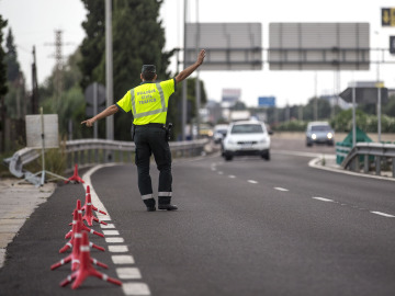 Un agente de la Guardia Civil de Tr&aacute;fico da el alto a un conductor en un control
