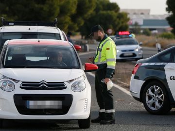 Un agente de la Guardia Civil da el alto a un veh&iacute;culo en un control de tr&aacute;fico