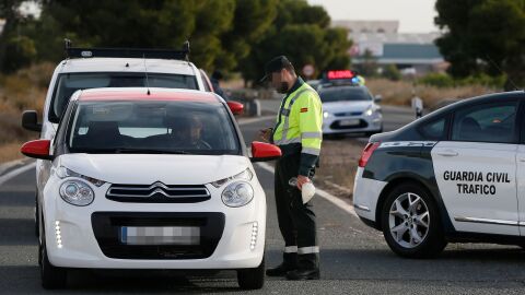 Un agente de la Guardia Civil da el alto a un vehículo en un control de tráfico