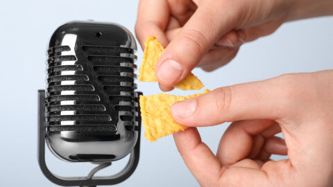 Unas manos rompen un snack cerca de un micrófono