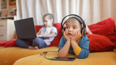 Dos niños usando dispositivos tecnológicos
