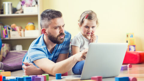 Un padre le enseña a su hija pequeña habilidades digitales.
