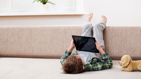 Un niño juega con su tablet dentro de casa