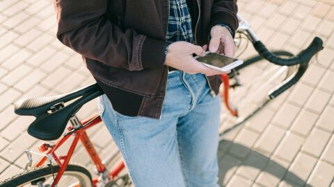 Ciclista parado usa el móvil