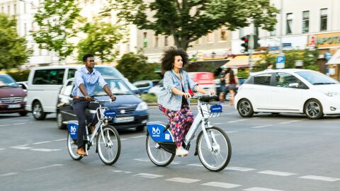 Dos ciclistas en bicicletas públicas urbanas