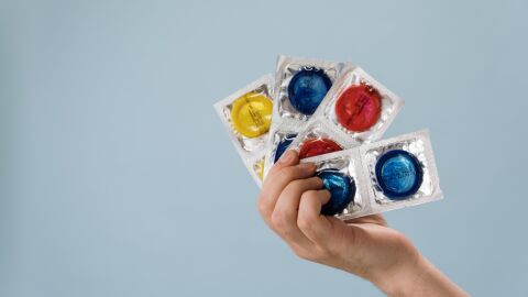 ‘Sal como quieras, pero no salgas sin condones’ es la nueva campaña de Sanidad para la prevención del VIH y otras ITS Condones desplegados a modo de abanico en la mano de un hombre