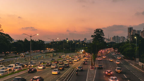 Coches al atardecer saliendo de la ciudad por autopista 