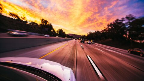 Turismo a gran velocidad por autopista al atardecer