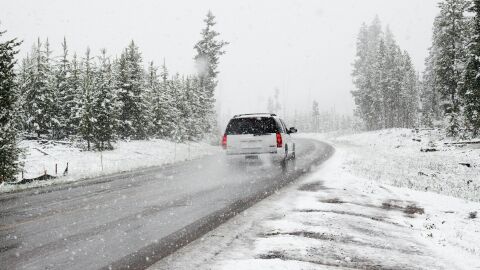 Coche por carretera mientras nieva