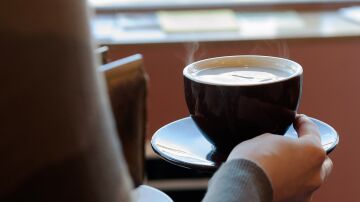 Imagen de una persona sujetando una taza de café