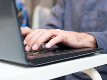 Imagen de archivo de una persona tecleando en un ordenador.