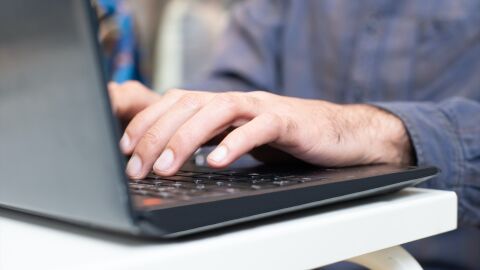 Imagen de archivo de una persona tecleando en un ordenador.