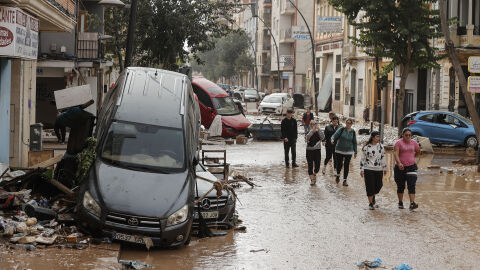 Calle cubierta de lodo y coches amontonados tras la DANA en Valencia.