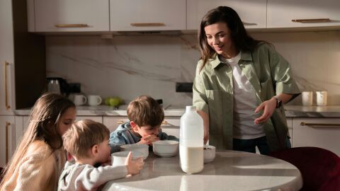 Madre dándole el desayuno a sus hijos