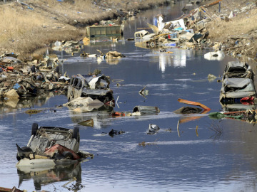  Coches, camiones y otros escombros sumergidos en el agua de un canal fluvial en Ichinomaki