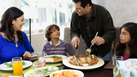 Unos padres sirven comida a sus hijos Unos padres sirven comida a sus hijos