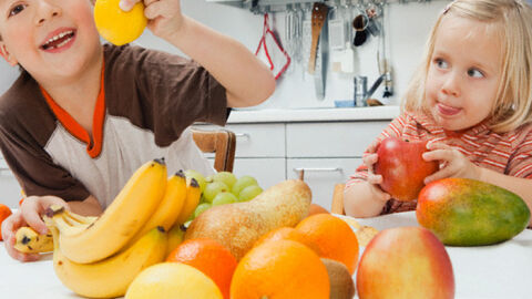 Un niño y una niña con fruta Un niño y una niña con fruta