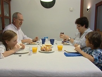 Abuelos comiendo con sus nietos