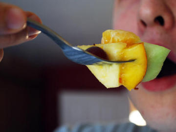 Adolescente comiendo fruta