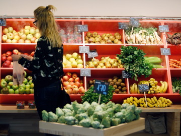 Una mujer hace la compra en la sección de frutas y verduras