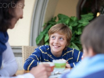 Niño comiendo en familia.