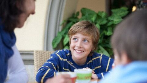 Niño comiendo en familia. Niño comiendo en familia.