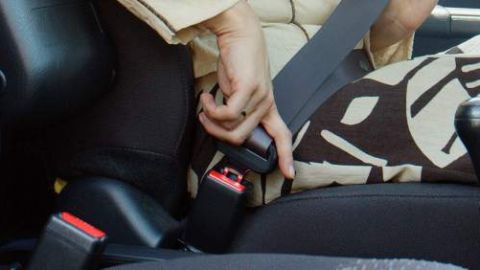 Una mujer se coloca el cinturón de seguridad