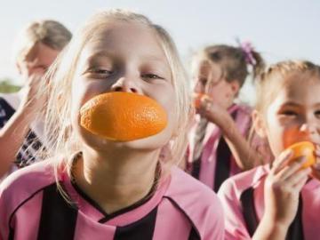 Niños practicando deporte y comiendo fruta