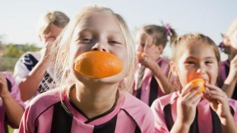 Niños practicando deporte y comiendo fruta Niños practicando deporte y comiendo fruta