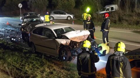 Los bomberos junto a dos vehículos implicados en un accidente