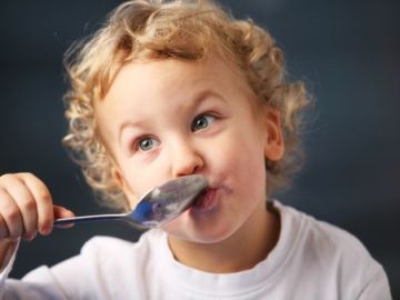 Un niño pequeño disfruta de un yogur