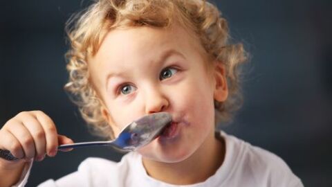 Un niño pequeño disfruta de un yogur Un niño pequeño disfruta de un yogur
