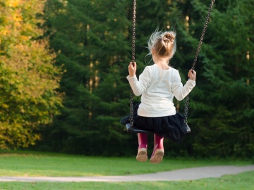 Una niña juega en un columpio