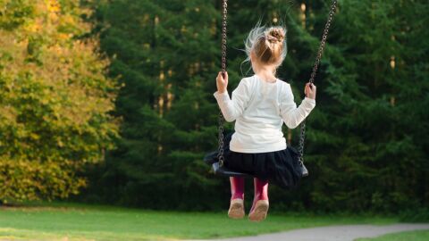 Una ni&ntilde;a juega en un columpio