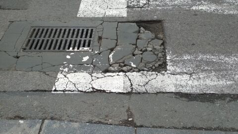 Grieta peligrosa en paso de cebra Piedras sueltas en paso de cebra por el que pasan continuamente autobuses y coches, con el consiguiente peligro para las personas que esperan en el semáforo. Dirección: c/ Virgen de Luján ( frente heladería La Jijonenca).Los Remedios. Sevilla.