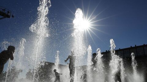 Un grupo de ni&ntilde;os se refresca en una fuente de Pamplona