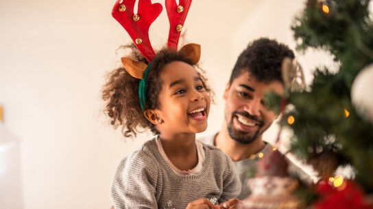 Niña emocionada decorando un árbol de Navidad Nova Life