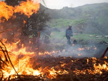 Un efectivo del Cuerpo de Bomberos de Cantabria durante las labores de extinción de un incendio forestal