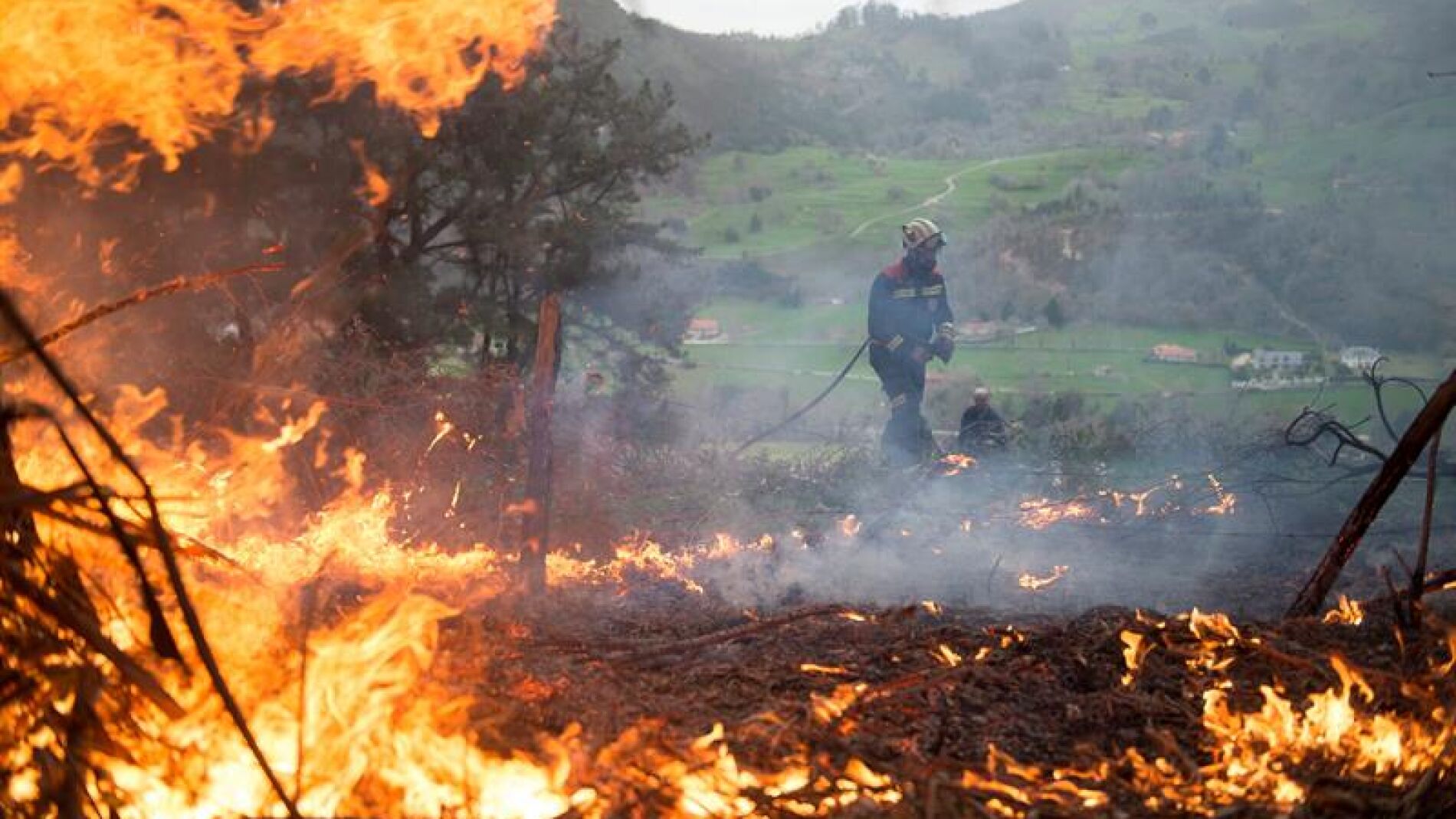 Un efectivo del Cuerpo de Bomberos de Cantabria durante las labores de extinción de un incendio forestal