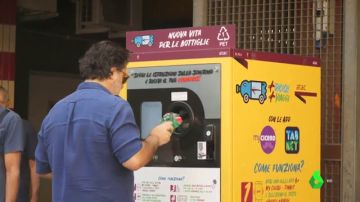 UN hombre tirando una botella de plástico a una máquina en Roma.