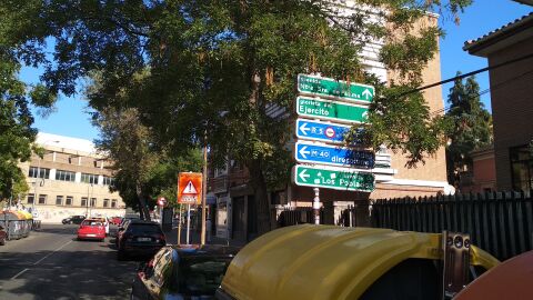 Señal informativa situada en la Calle Federico Grases 3, Carabanchel (Madrid). Indica dirección a la izquierda y unos metros más adelante, antes del cruce, hay una señal vertical que indica la prohibición de girar a la izquierda. Es una contradicción.