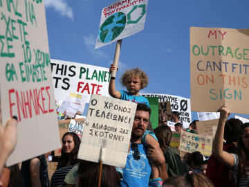 Un hombre lleva a un niño sobre sus hombros durante una manifestación de la Global Climate Strike del movimiento Viernes para el Futuro en Atenas