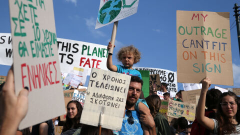 Un hombre lleva a un ni&ntilde;o sobre sus hombros durante una manifestaci&oacute;n de la Global Climate Strike del movimiento Viernes para el Futuro en Atenas