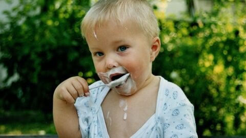Ni&ntilde;o comi&eacute;ndose un yogur 