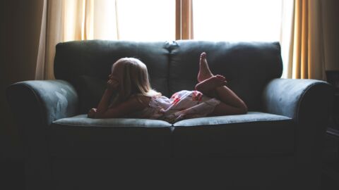 Niña tumbada en el sofá Niña tumbada en el sofá