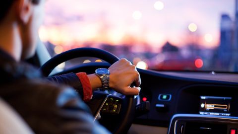 Conductor al volante al anochecer