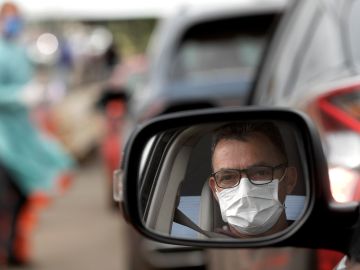 Un hombre con mascarilla en su coche