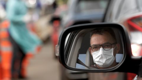 Un hombre con mascarilla en su coche